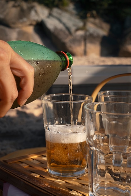 Personne versant une boisson au guarana dans un verre de bouteille