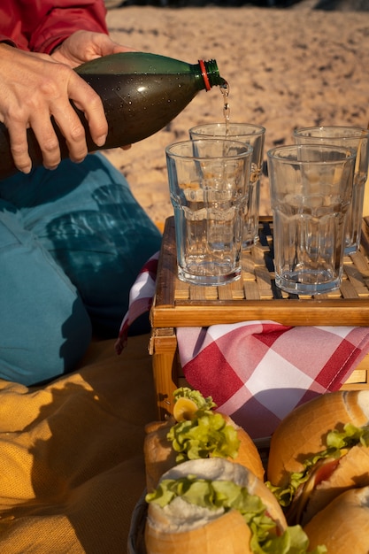 Photo gratuite personne versant une boisson au guarana dans un verre de bouteille