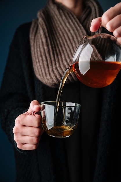 Photo gratuite personne versant un thé délicieux dans une tasse