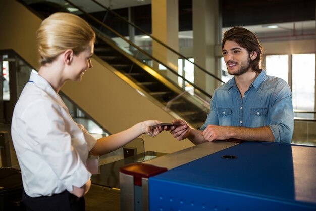 Personnel féminin donnant la carte d'embarquement au passager