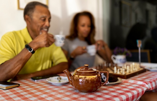 Personnes âgées floues à coup moyen avec des tasses à thé