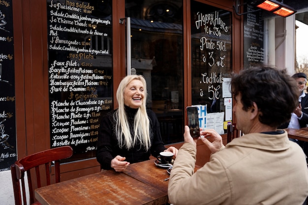 Photo gratuite personnes âgées souriantes à coup moyen au bistro