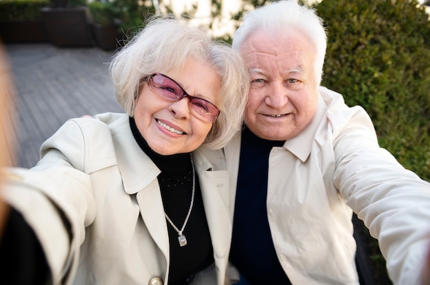 Photo gratuite personnes âgées souriantes à coup moyen prenant selfie