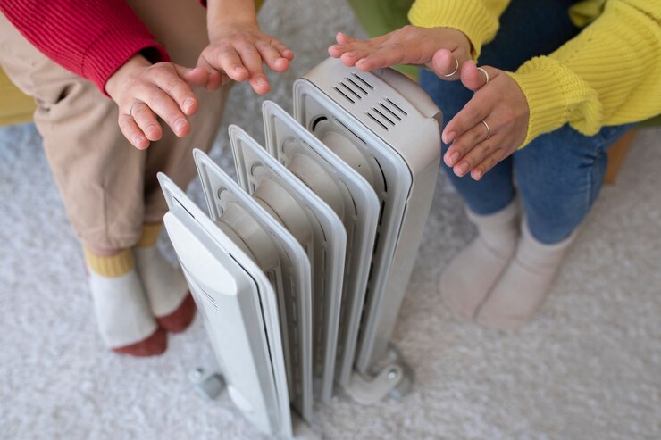 Photo gratuit les personnes à angle élevé se réchauffent près du radiateur