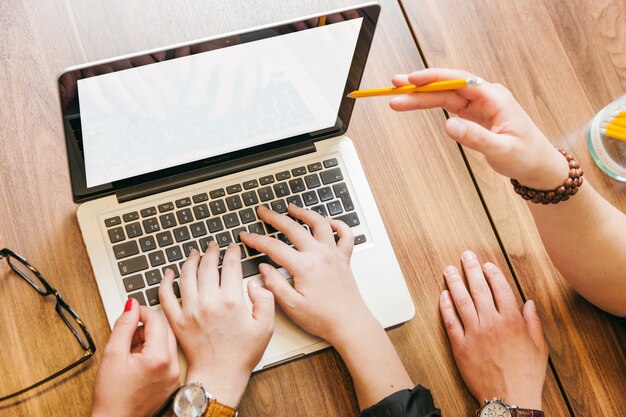 Personnes assises à la bureau travaillant sur ordinateur portable