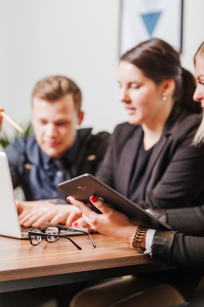 Personnes assises à la bureau travaillant sur ordinateur portable