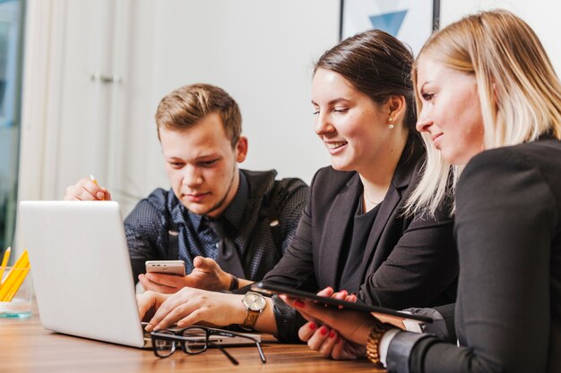 Personnes assises à la bureau travaillant sur ordinateur portable