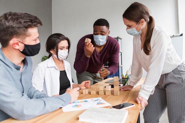Les personnes ayant une réunion au bureau avec des masques pendant la pandémie