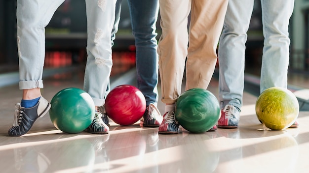 Photo gratuite personnes avec des boules de bowling colorées