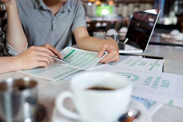 Personnes cultivées étudiant la brochure sur l'assurance-vie