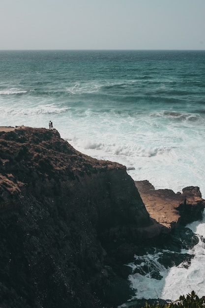 Photo gratuite personnes debout sur la falaise pendant la journée