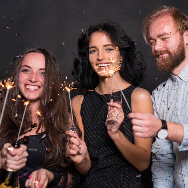 Photo gratuite personnes debout avec des feux de bengale sur la fête