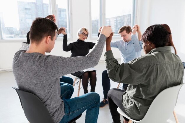 Personnes debout les yeux fermés et levant les mains