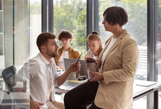 Photo gratuite personnes discutant au travail vue latérale