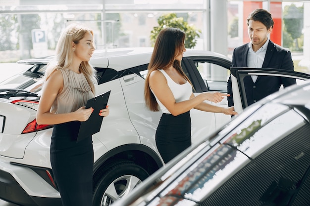 Photo gratuite personnes élégantes et élégantes dans un salon de l'automobile