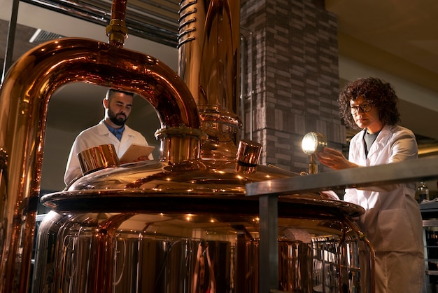 Photo gratuite personnes à faible angle travaillant dans une usine de bière