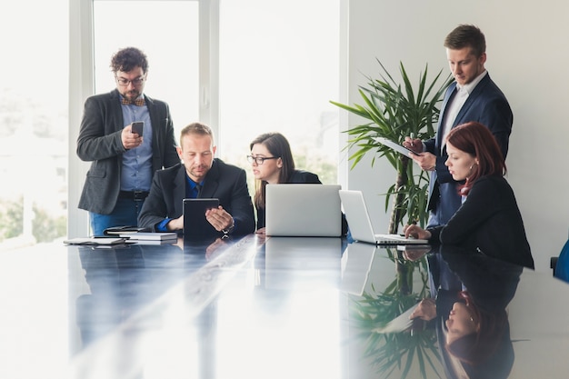 Personnes formelles avec des gadgets en réunion