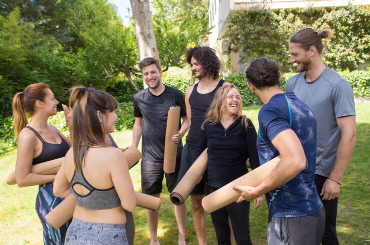 Photo gratuit personnes gaies avec des tapis de yoga bavardant et riant