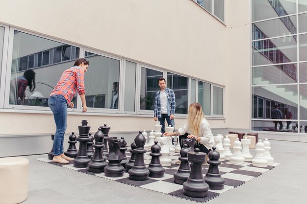 Personnes jouant aux échecs géants sur le campus