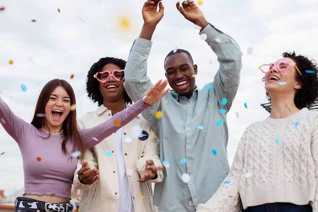 Personnes à plan moyen faisant la fête avec des confettis