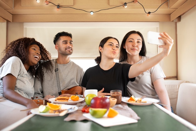 Personnes à plan moyen prenant un selfie avec un téléphone