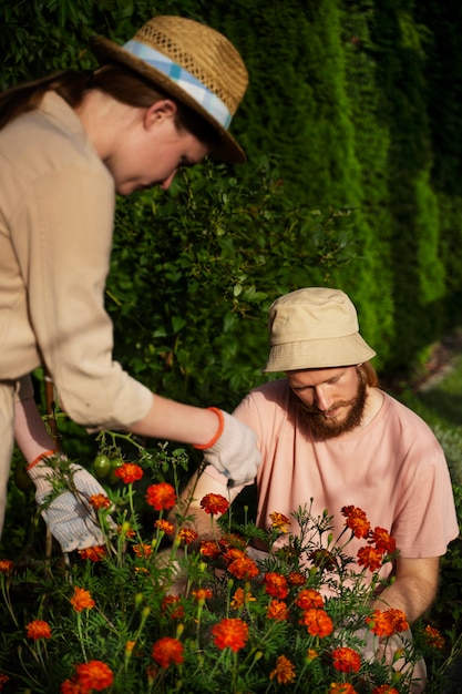 Photo gratuite personnes à plan moyen prenant soin des fleurs