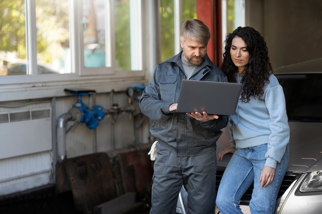 Photo gratuite personnes à plan moyen regardant un ordinateur portable