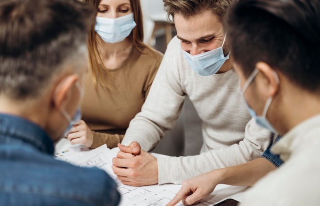 Personnes portant des masques médicaux au travail