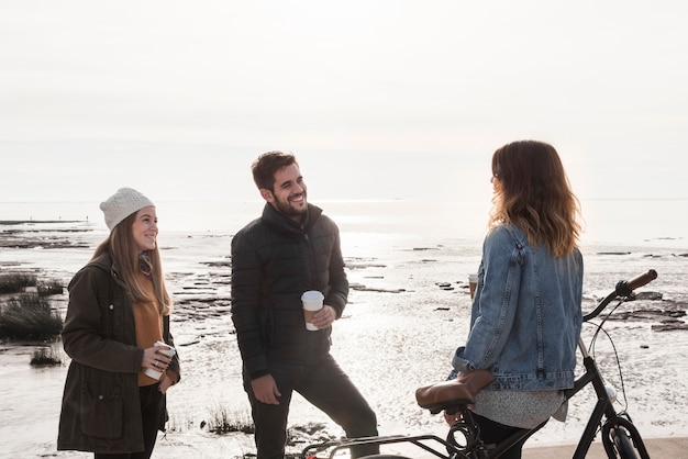 Personnes portant des vêtements chauds parlant au bord de la mer