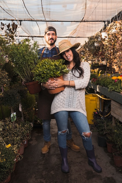 Personnes posant avec des pots dans la serre