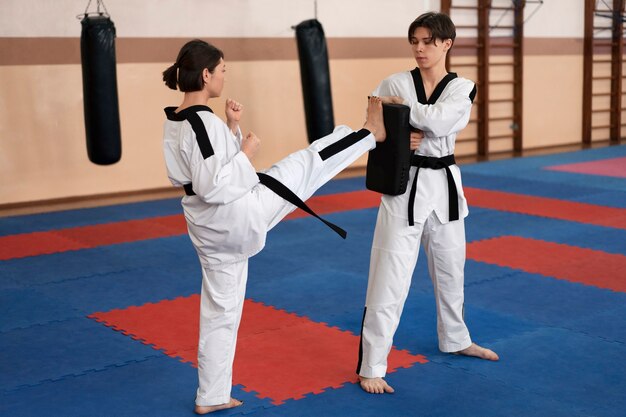 Personnes pratiquant le taekwondo dans un gymnase