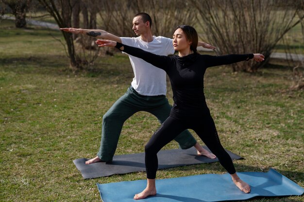 Photo gratuite personnes pratiquant le yoga à l'extérieur