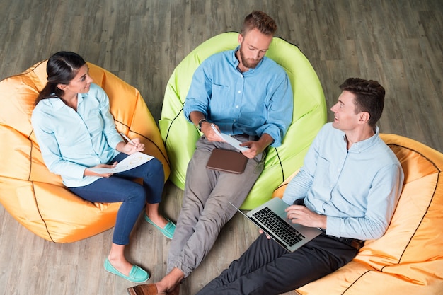 Les personnes qui discutent du projet sur les chaises Beanbag