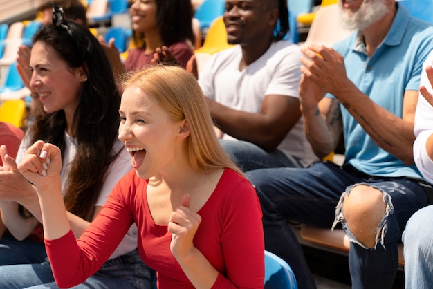 Personnes regardant un match de football par une journée ensoleillée