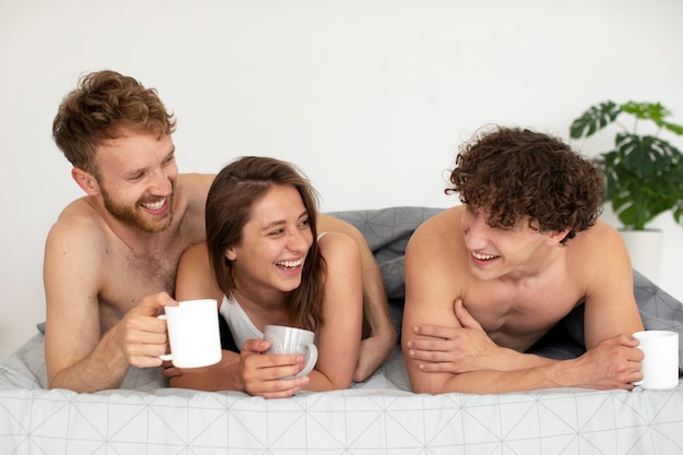 Personnes souriantes allongées dans le lit vue de face