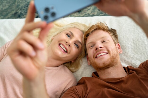 Personnes souriantes à angle élevé prenant selfie