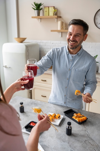 Personnes souriantes avec commande de sushi grand angle