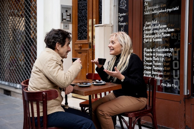 Photo gratuite personnes souriantes à coup moyen au bistro