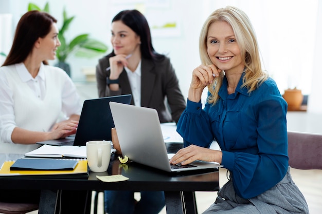 Personnes souriantes à coup moyen au bureau