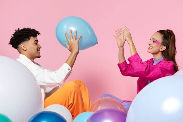 Personnes souriantes à coup moyen jouant avec un ballon