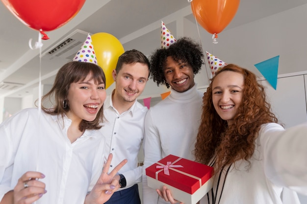 Photo gratuite personnes souriantes à coup moyen prenant selfie