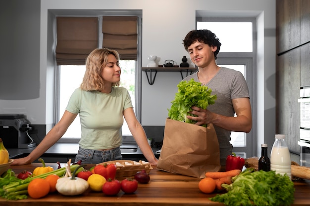 Personnes souriantes à coup moyen avec des produits d'épicerie