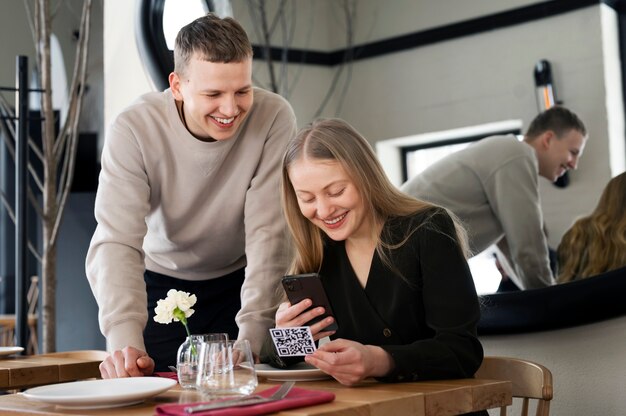 Personnes souriantes à coup moyen scannant qr