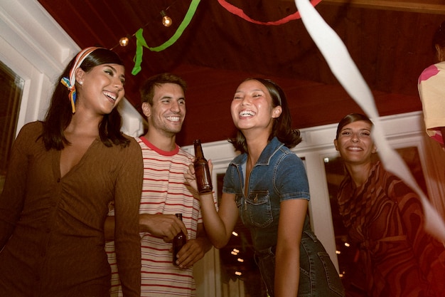 Photo gratuite personnes souriantes faisant la fête en contre-plongée