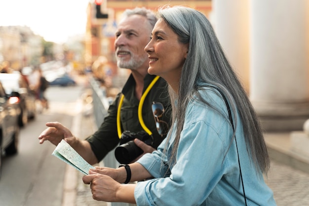 Photo gratuite personnes souriantes à plan moyen avec carte