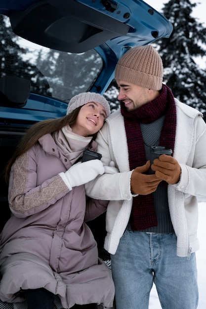 Personnes souriantes à plan moyen avec voiture