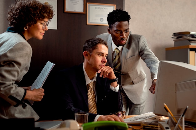 Personnes de style vintage travaillant dans un bureau avec des ordinateurs