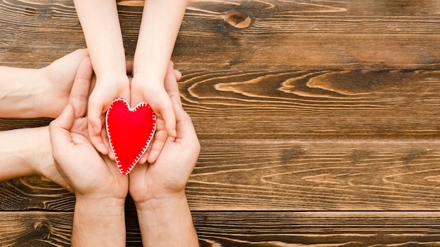 Personnes tenant un coeur rouge dans les mains avec copie espace