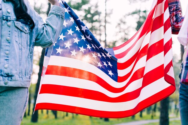 Personnes tenant le drapeau des Etats-Unis dans le parc