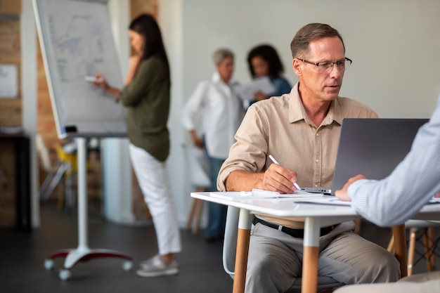 Personnes utilisant un appareil numérique lors d'une réunion